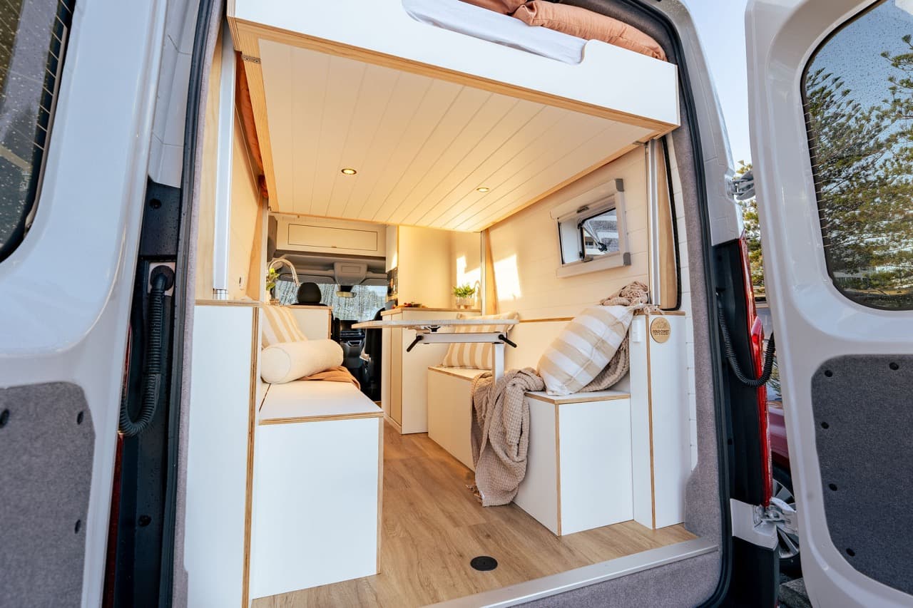 Rear doors open onto the lounge seating and dining table